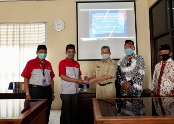 Adi Subagyo Pimpinan Kepala Cabang JNE Yogyakarta menyerahkan cinderamata sebagai simbol kerjasama