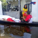 Kurir JNE Banjarmasin antarkan paket pelanggan di tengah banjir yang melanda.