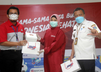 Penyerahan simbolis dukungan konsumsi dari JNE untuk petugas medis kepada Camat Grogol Petamburan, Didit Sumaryanta (baju putih)