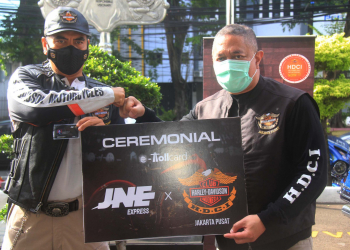 Presiden Direktur JNE M. Feriadi (kanan) secara simbolis memberikan e-Toll Card kepada anggota HDCI Jakarta Pusat
