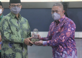 Gubernur DKI Jakarta Anies Baswedan menyerahkan penghargaan Muzakki Istimewa Award kepada Presiden Direktur JNE M. Feriadi sebagai perusahaan terkolaborasi tahun 2021. Foto: JNE