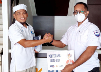 Branch Manager JNE Jayapura, Henry, menyerahkan donasi mushaf Al Quran untuk masjid di lingkungan Bulog Papua.