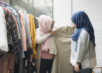 Two young Malaysian women shopping clothes at the boutique.