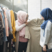 Two young Malaysian women shopping clothes at the boutique.