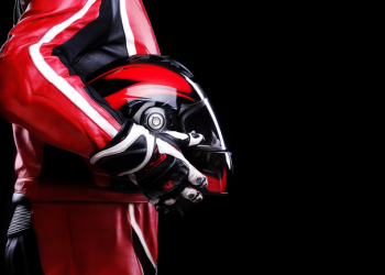 closeup of biker holding helmet side view on black background