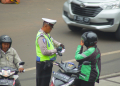 Seorang polisi yang sedang menilang pengendara motor di kawasan Blok M, Jakarta Selatan. Foto: Istimewa.