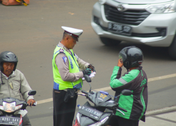 Seorang polisi yang sedang menilang pengendara motor di kawasan Blok M, Jakarta Selatan. Foto: Istimewa.