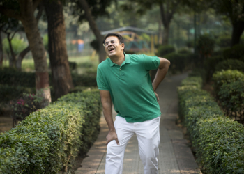 Man suffering from body pain while walking at park