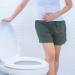A woman is sitting on toilet with diarrhea or constipated pain concept