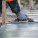 A construction worker is Smoothing wet cement