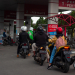 Bandung, Indonesia September 29, 2022 : Queue of motorcycles at public refueling statios in Kopo area of Bandung after petralite increase to Rp. 10.000. Selective focus object and people