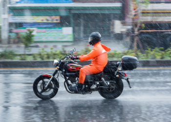 Nonthaburi: Motion Blurred panning photo of Unidentified name people riding motorcycle in the rain on road at Nonthaburi, Thailand.