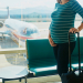 Pregnant woman at second trimester traveling by plane. Mother to be going to vacation or business trip. Is it safe to travel during pregnancy concept